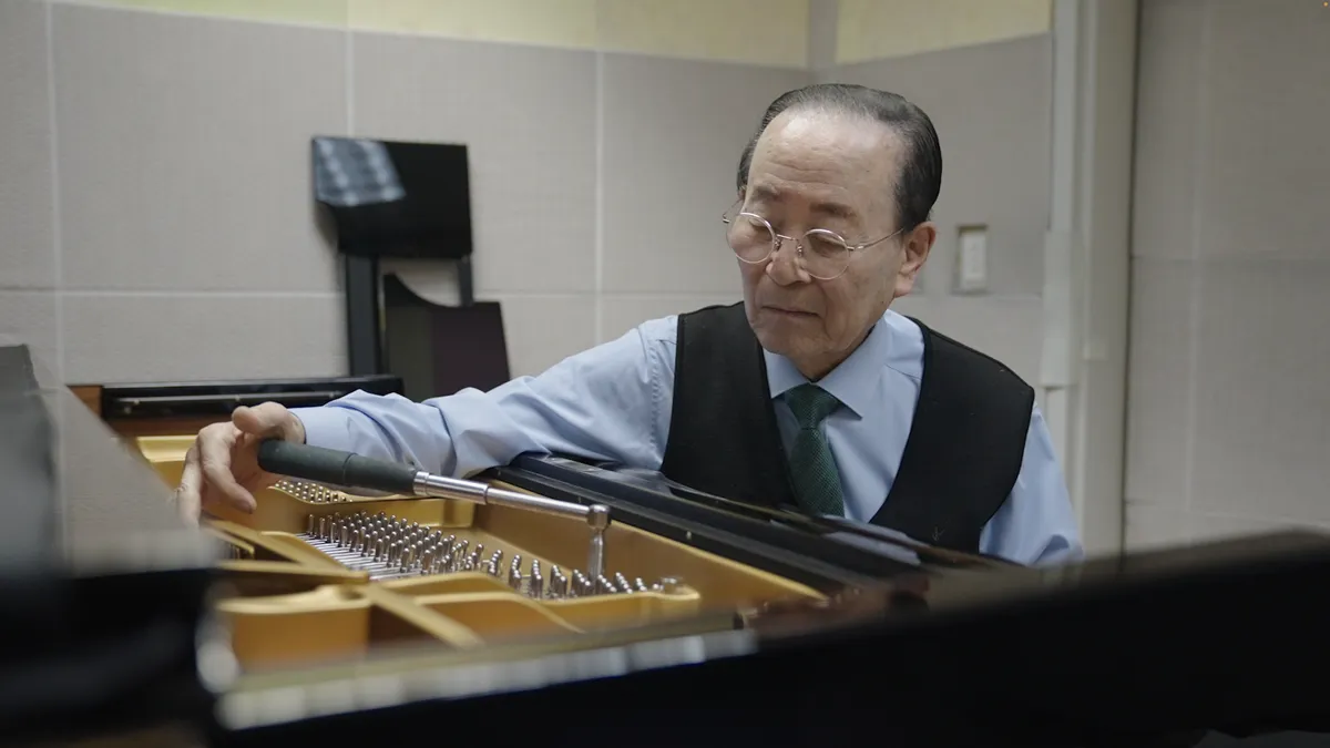 Dos pianistas interpretando juntos en un mismo piano durante el concierto conmemorativo